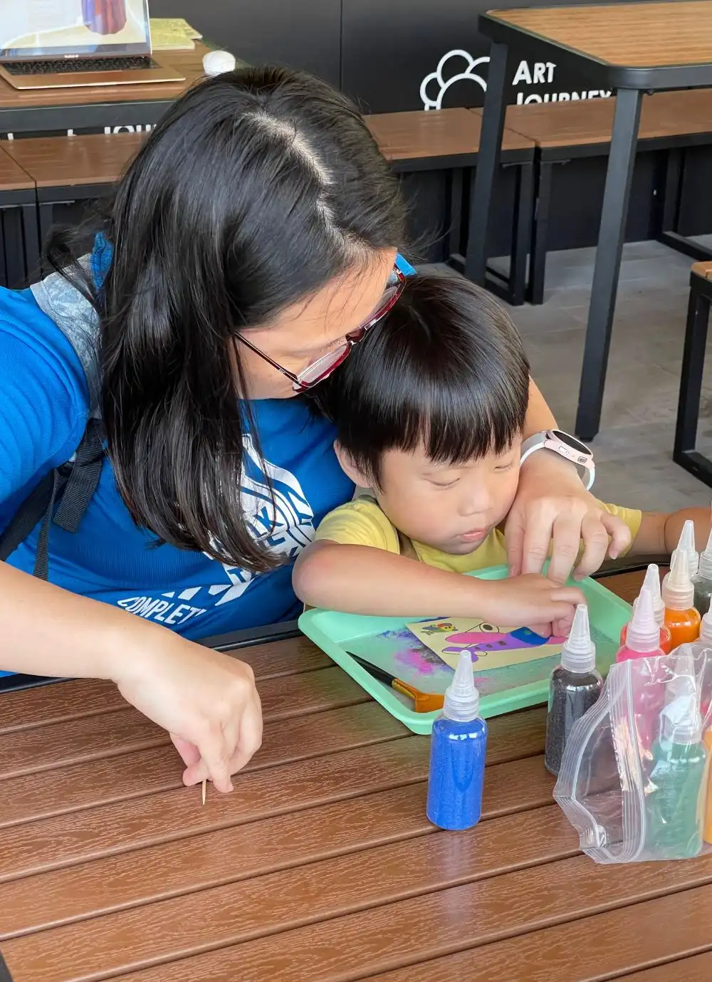 parent and child creating sand artwork together during the workshop.