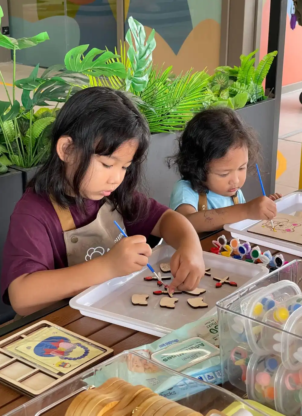 Close-up of a child pouring bright coloured sand onto a sand art board.