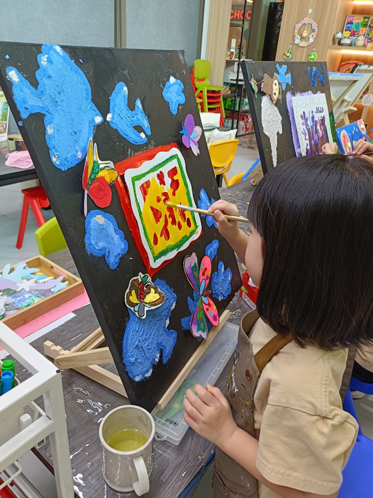 Father and young son painting a 3D figurine together during an art jamming session at Art Journey Singapore studio