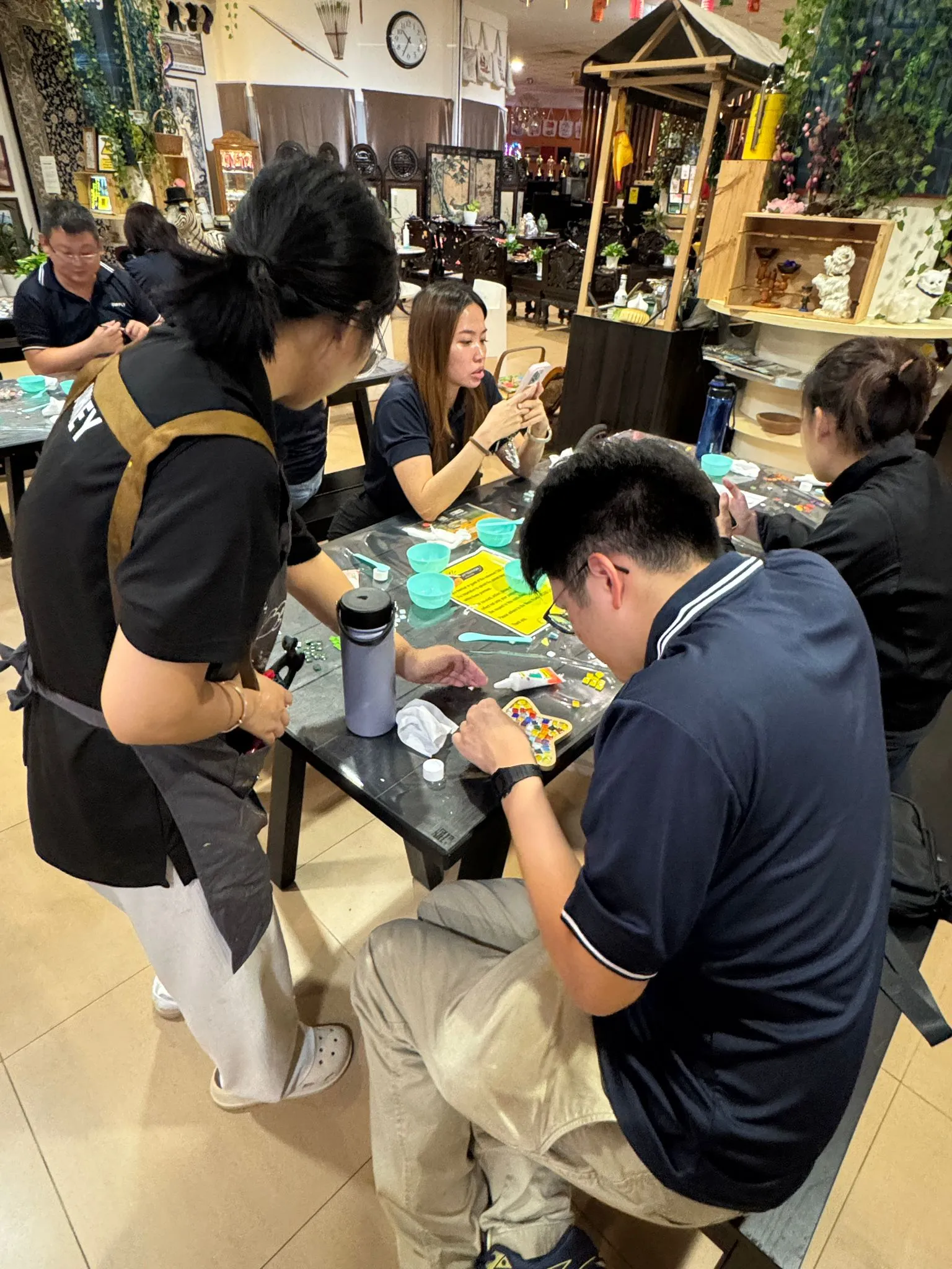 Family enjoying an art jamming session together at Art Journey Singapore — parent and child painting figurines