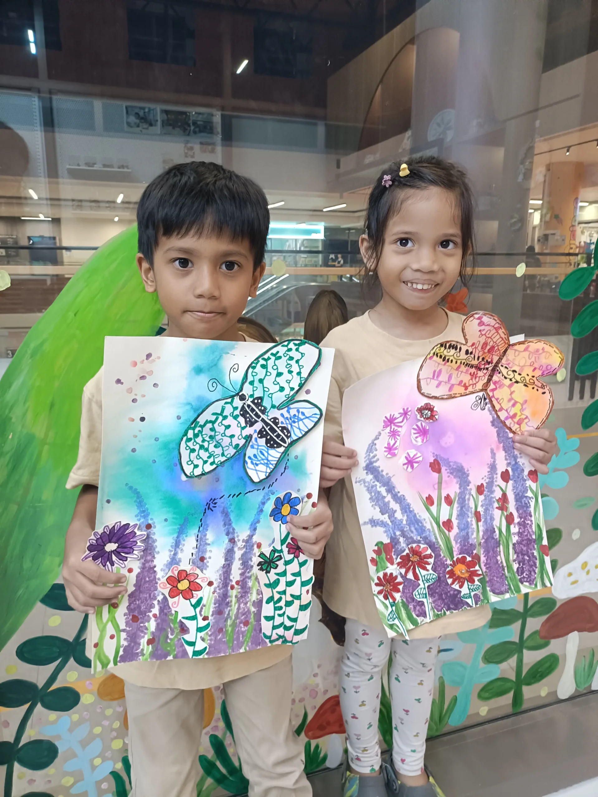 Primary school children holding their completed artworks from Art Journey Singapore workshop session