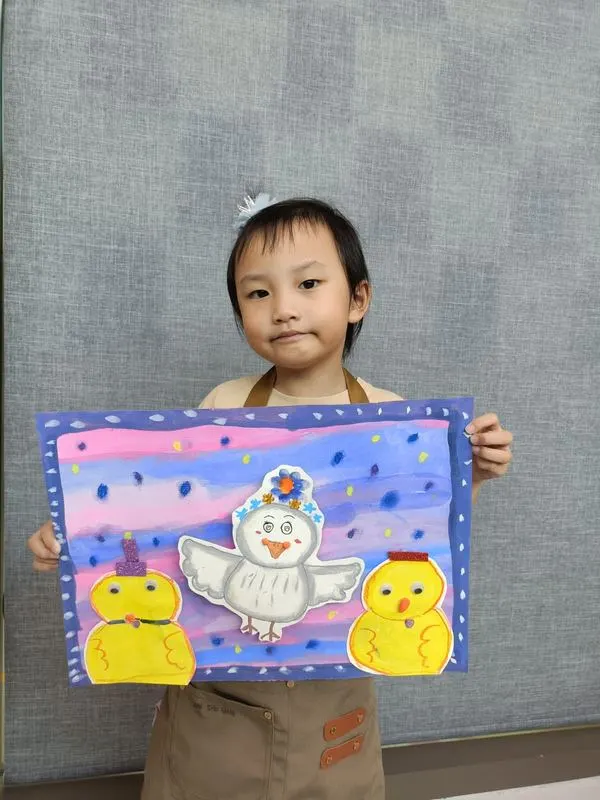 Young child proudly showing her cute chick and hen painting made at Art Journey Singapore