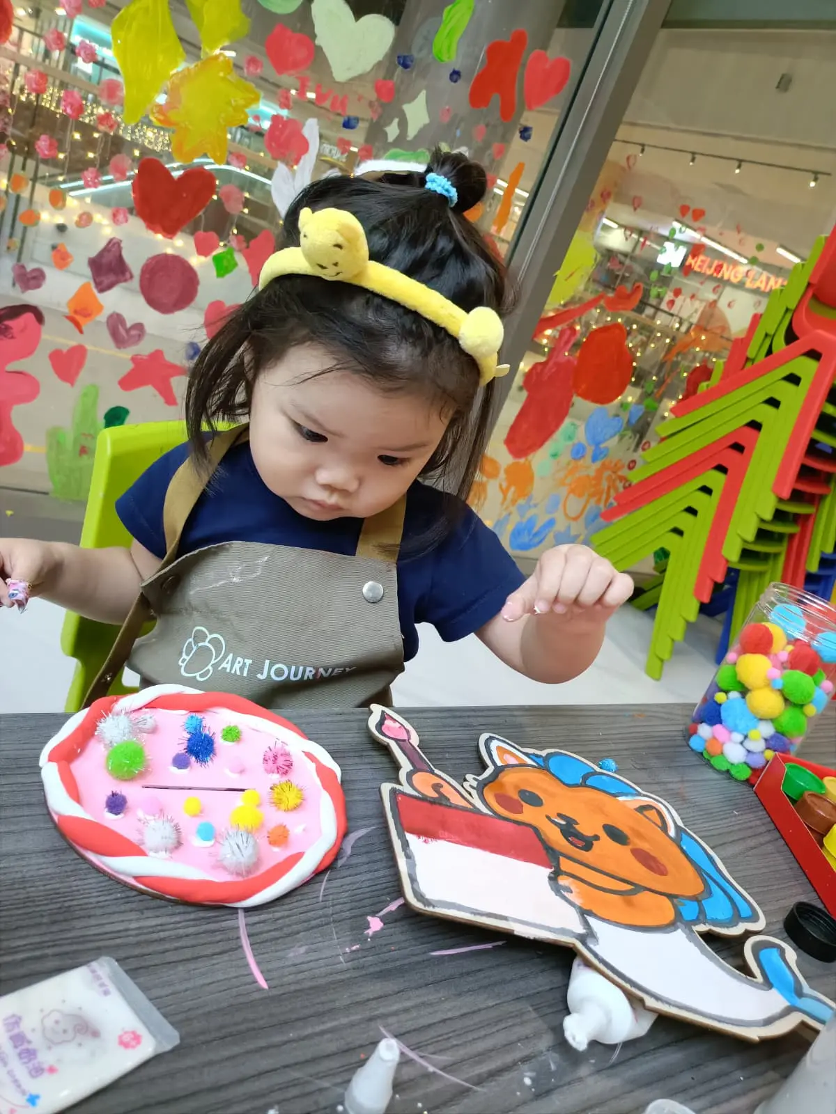 Child creating a patriotic art project for Singapore National Day celebration