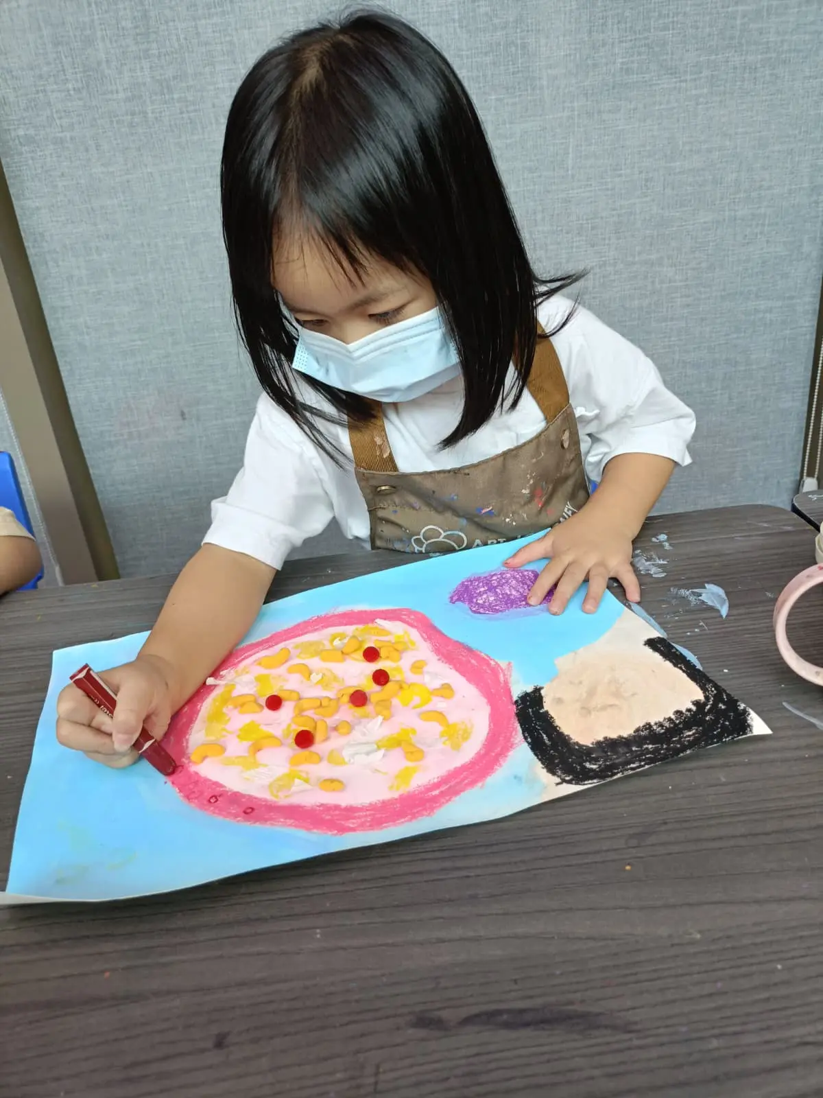 Child focused on a creative art project instead of a screen during the June school holidays at Art Journey Singapore