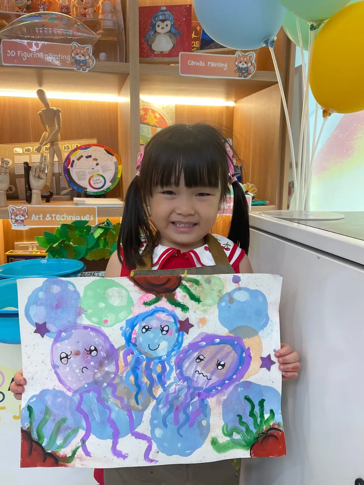 Child proudly showing their finished artwork to parent after completing their first art workshop at Art Journey Singapore