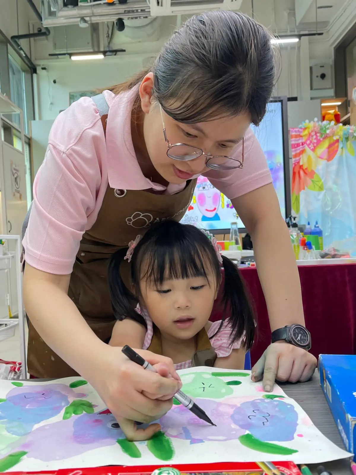 Child settling in at their first art workshop at Art Journey Singapore with instructor guiding them