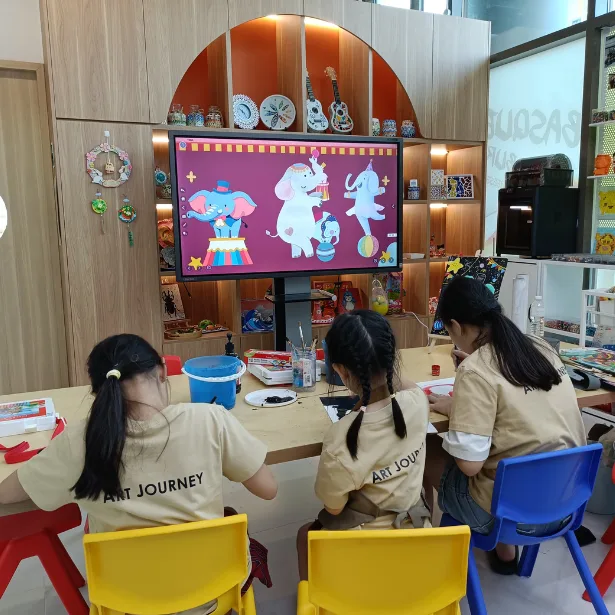Facilitator guiding young artists during holiday art class in Singapore