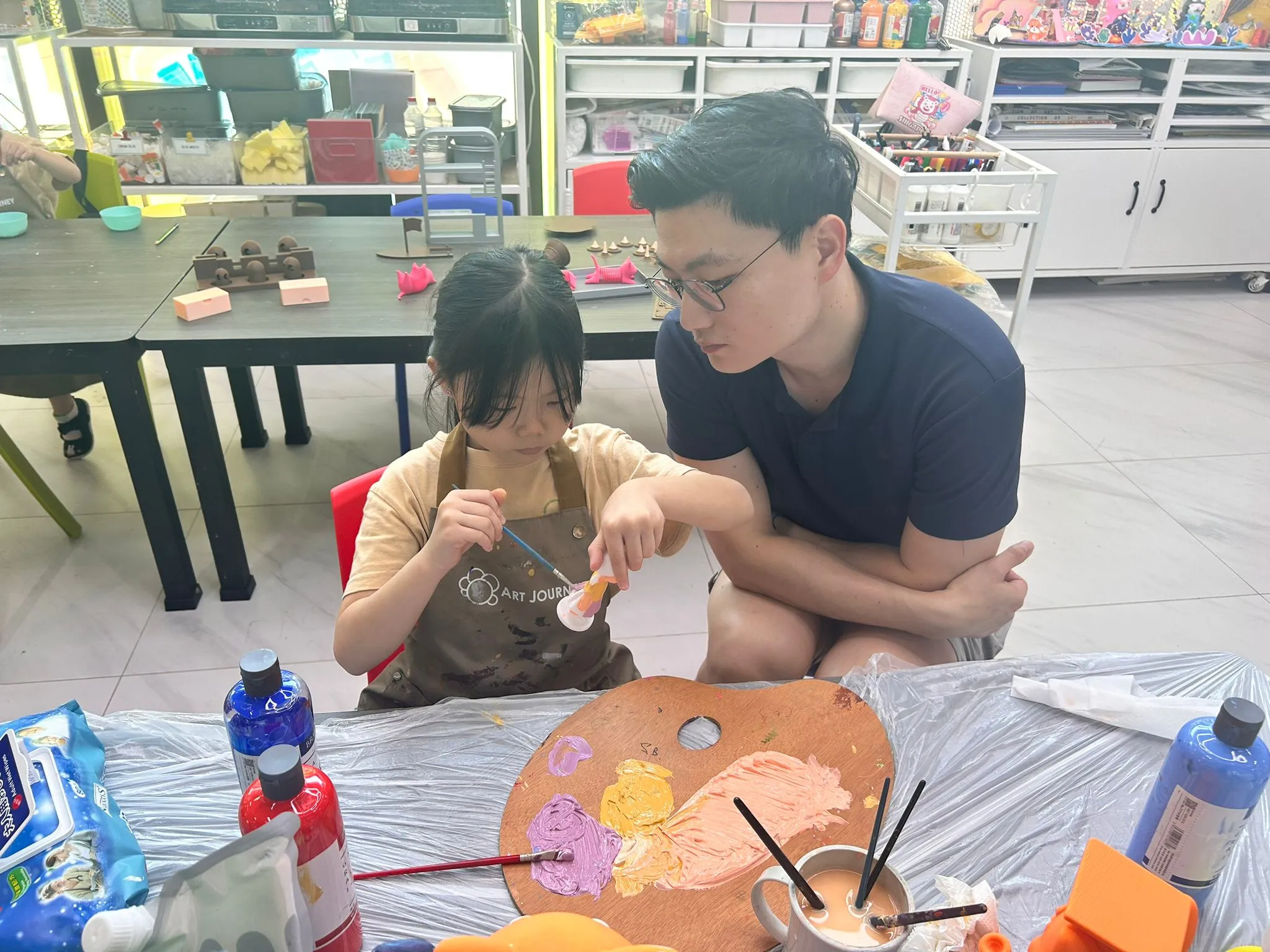 Father and son bonding over a creative activity during a family art session at Art Journey Singapore