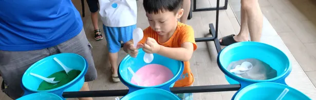 Preschooler making a layered sand art piece