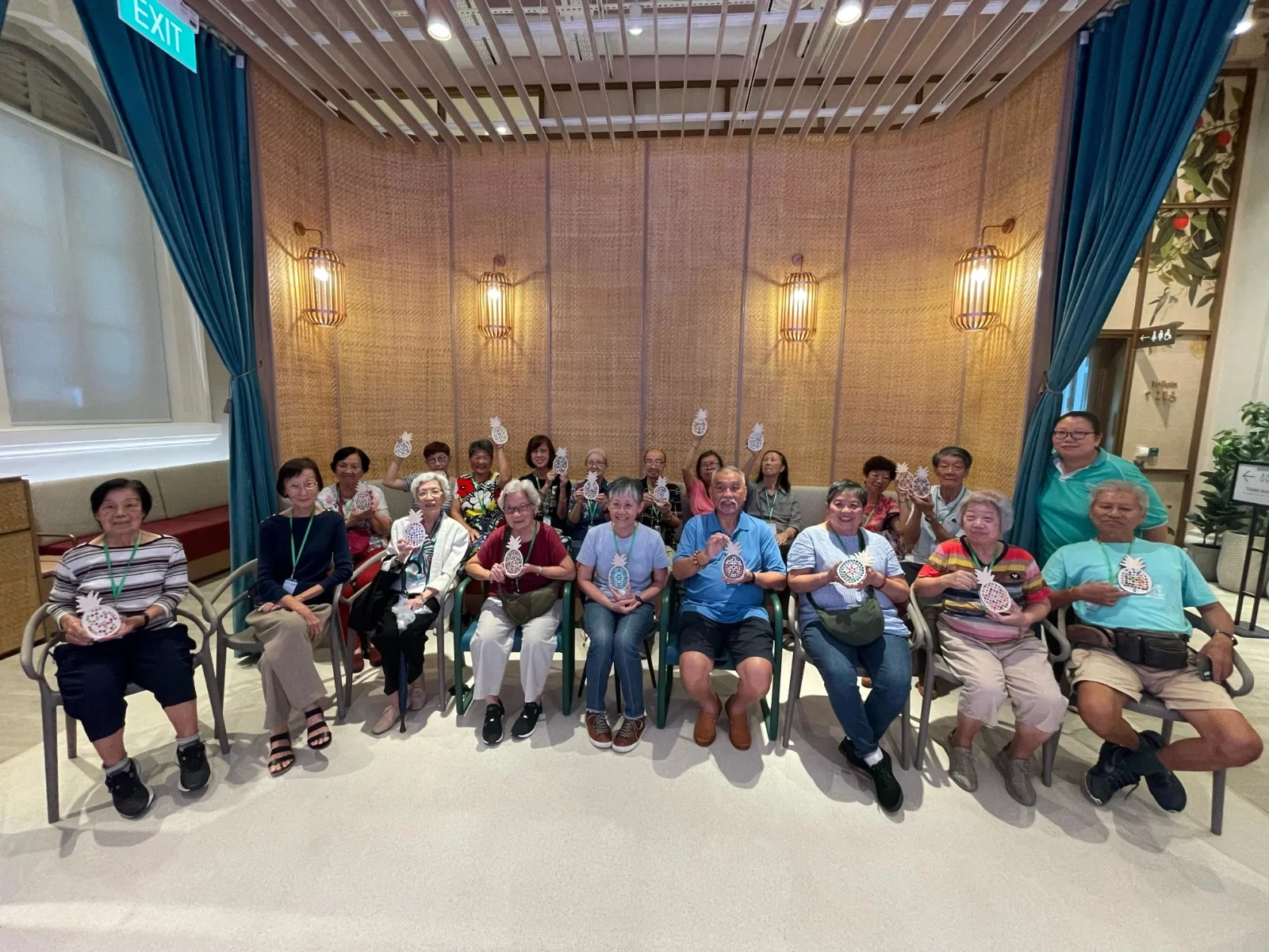 Seniors proudly holding their finished artworks after a creative session at Art Journey Singapore