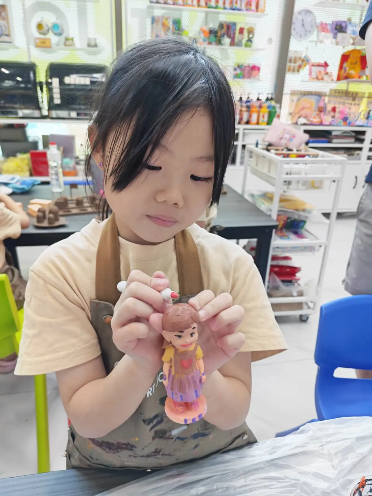 Child painting a 3D figurine