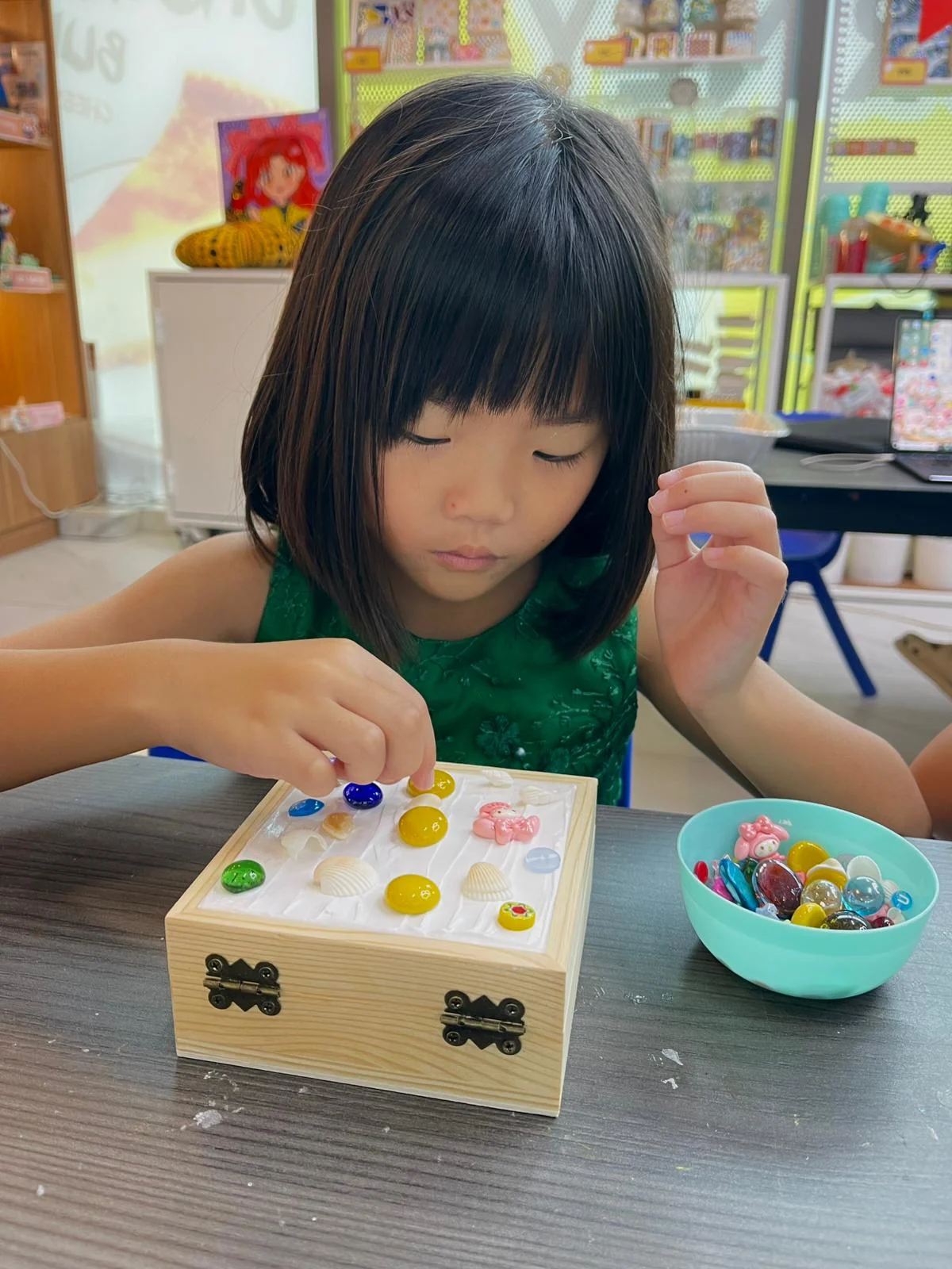 Young child carefully working on a detailed mosaic art project at Art Journey Singapore