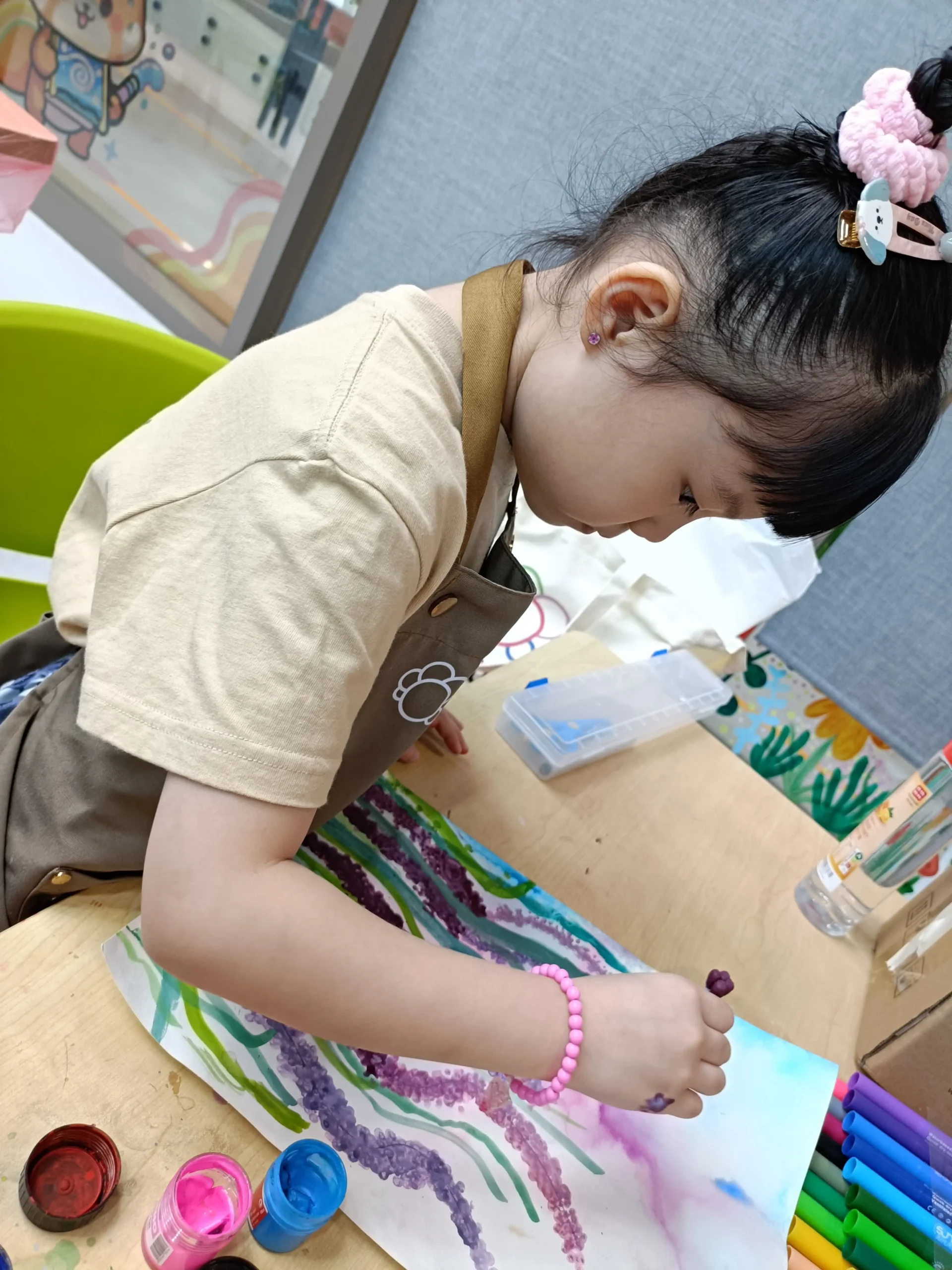 Child deeply focused on creating artwork during an Art Journey workshop session
