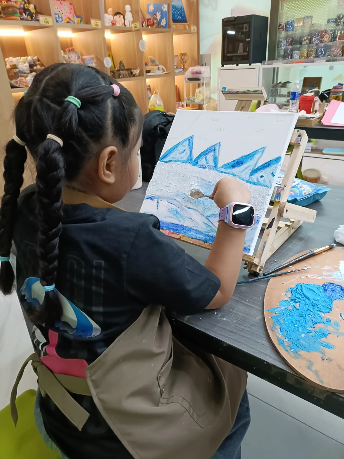 Child happily painting during a drop-in art workshop session at Art Journey Singapore