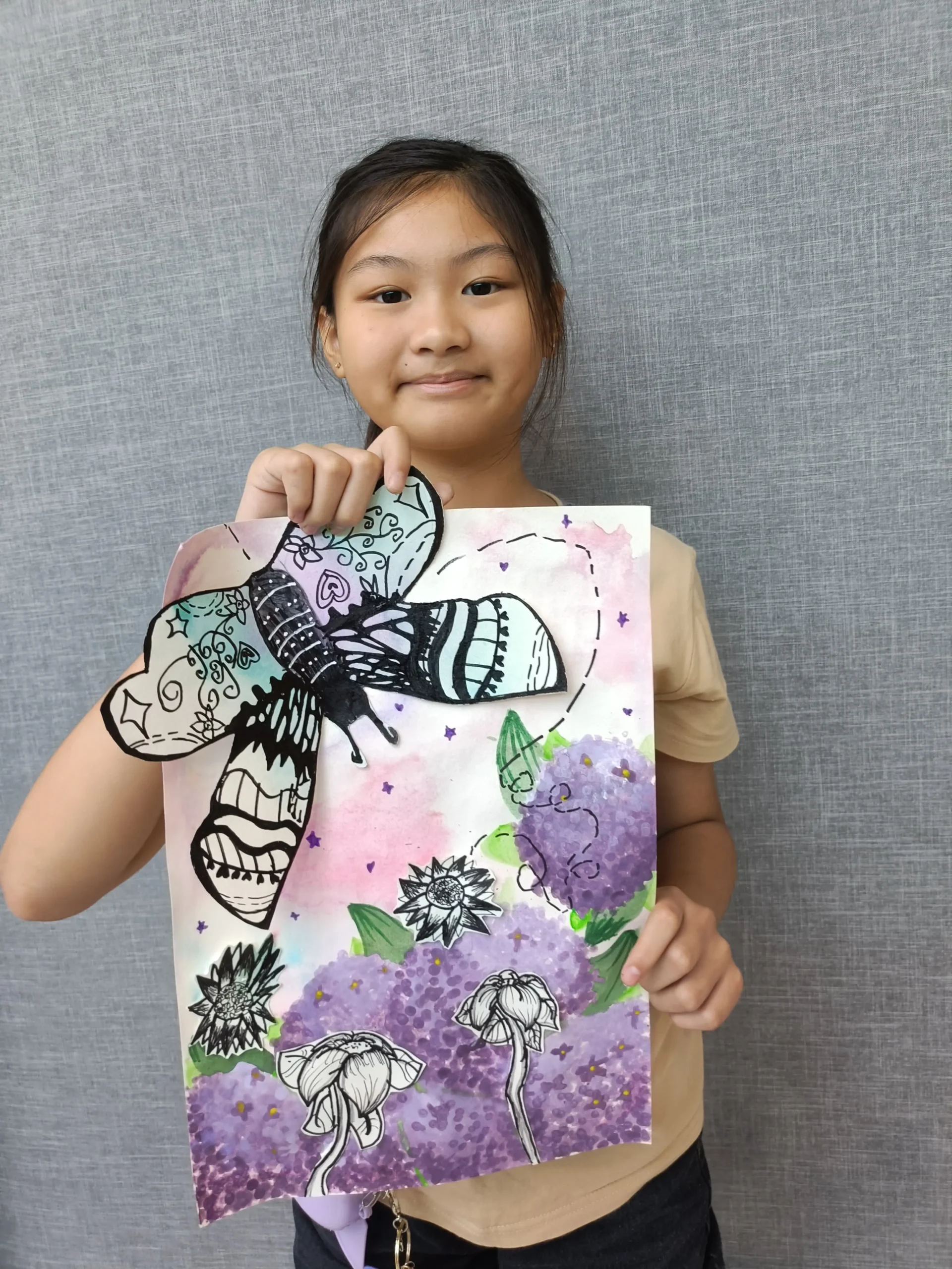 Child proudly holding their completed artwork after finishing an Art Journey workshop session