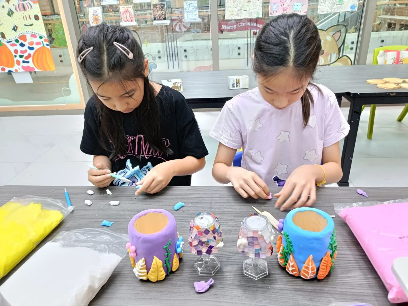 Child working with mixed media materials including clay mosaic tiles and paint during Art Journey Singapore workshop