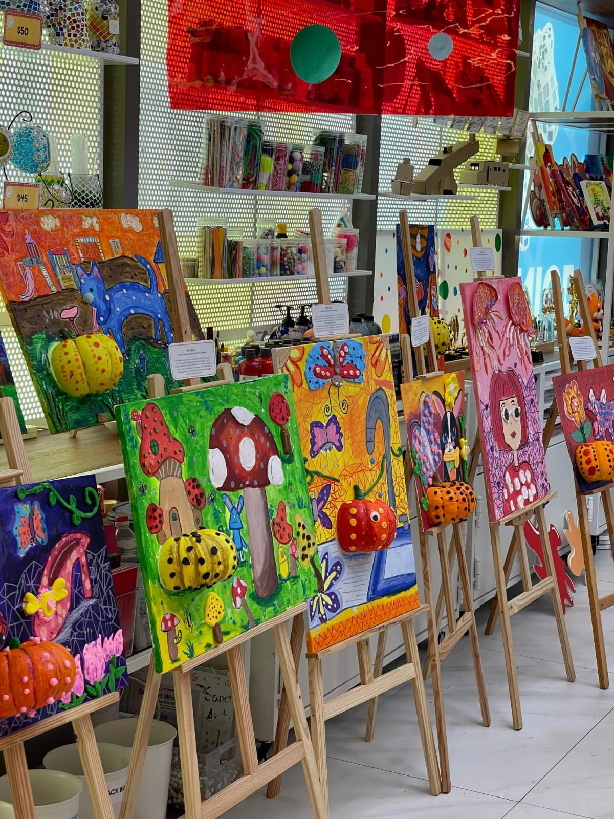 Collection of children's artwork paintings and crafts displayed at home in a Singapore HDB flat