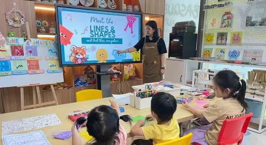 Preschooler watching a short video introduction to a theme at Art Journey Singapore