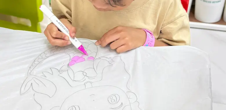 Young artist applying brush technique during a kids art workshop at Art Journey Singapore