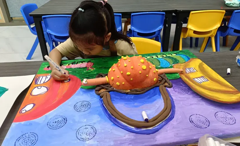 Child happily engaged in a creative art workshop at Art Journey Singapore after initial reluctance
