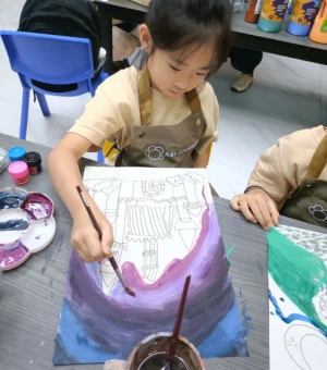 Young artist painting with acrylics during a kids art workshop session at Art Journey Singapore