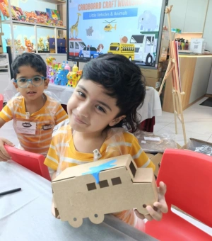 Young creators building cardboard vehicles during a craft workshop at Art Journey Singapore