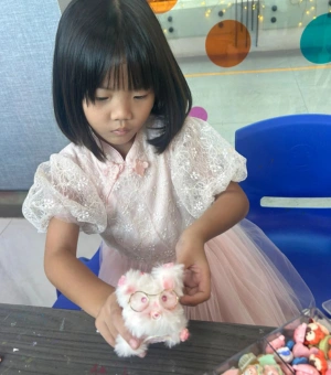 Young girl crafting a fluffy Twist and Turn Pet during art jamming at Art Journey Singapore