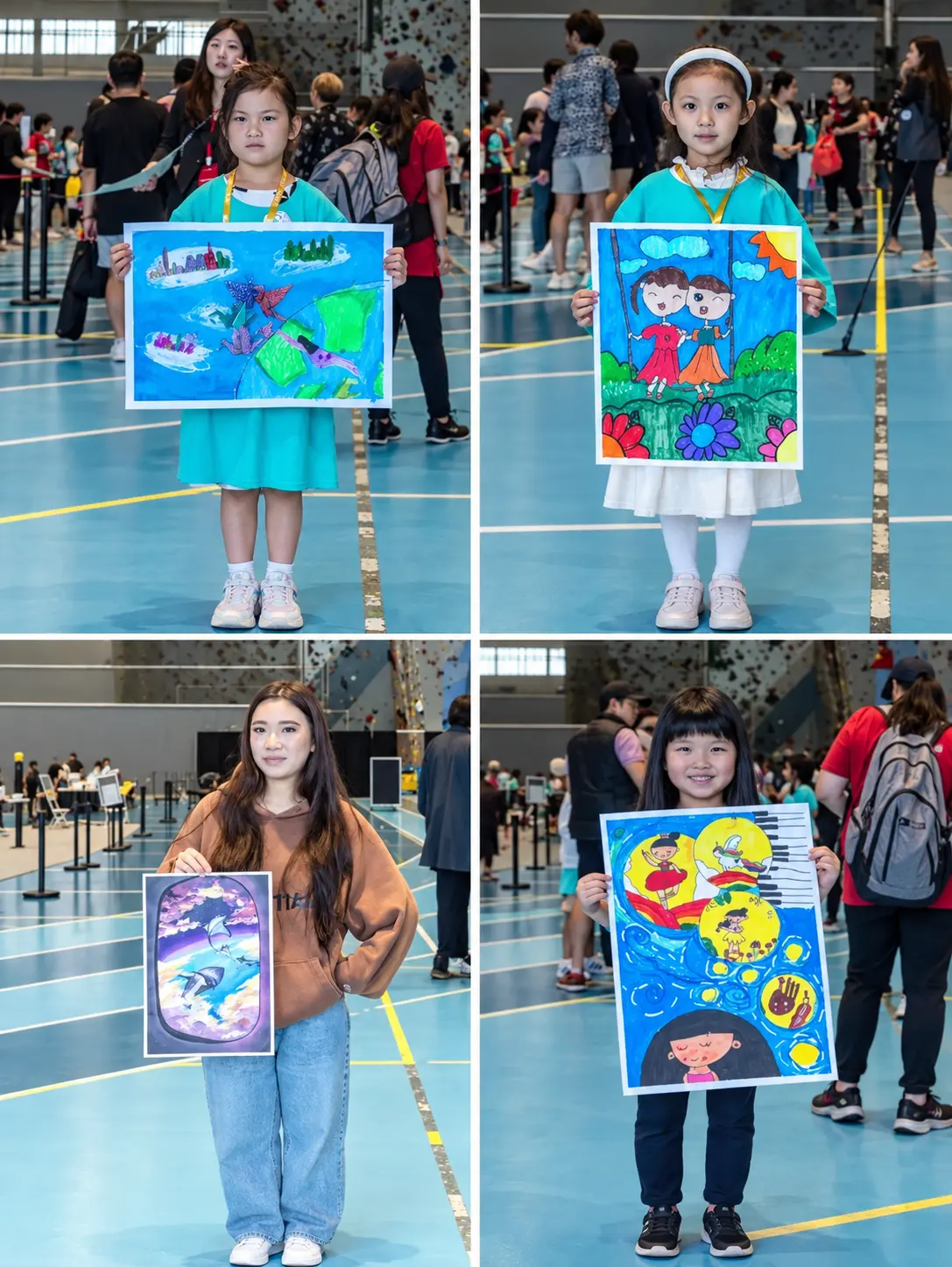 Participants holding up their finished paintings at the competition venue