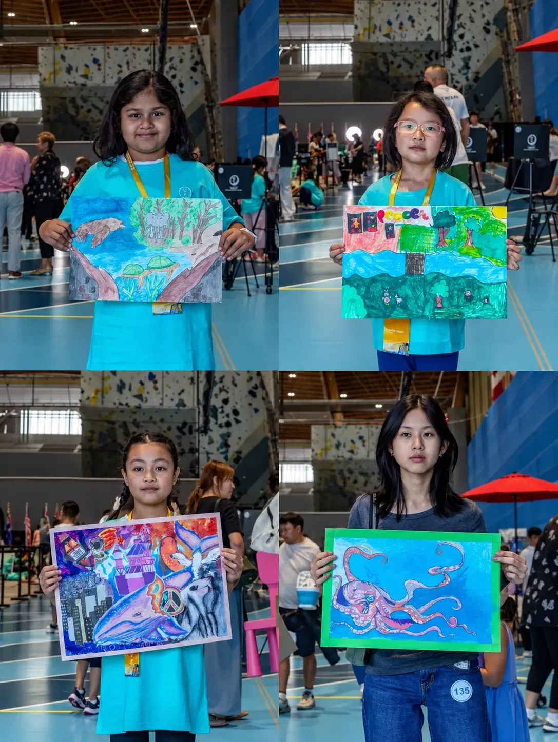 Participants holding up their finished paintings at the competition venue