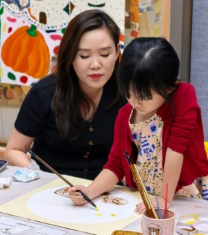art-teacher-guiding-child-kids-art-workshop