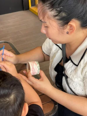 Instructor guiding a child through ceramic painting technique