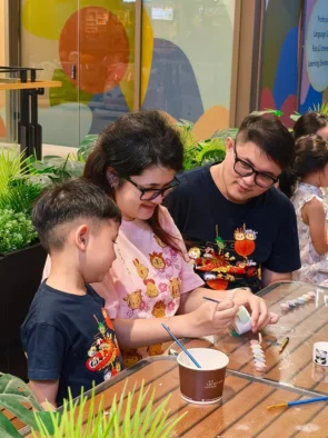 Parents and child working on ceramics and painting together