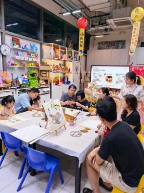 Group pottery painting workshop in progress at the Art Journey studio