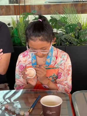 Girl concentrating on her mini cup at a pottery painting singapore session