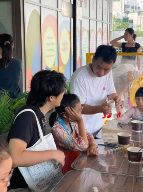 Families seated together at a pottery painting studio table in Singapore