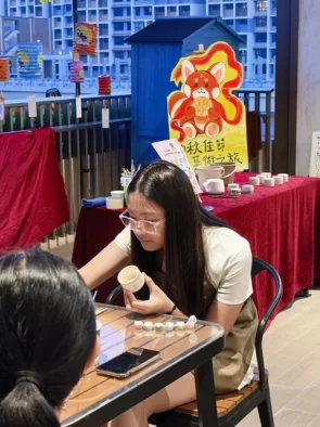Teenager painting a ceramic cup at an outdoor pottery painting event